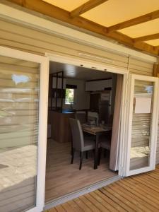 a sliding glass door leading into a dining room with a table at camping la carabasse in Vias