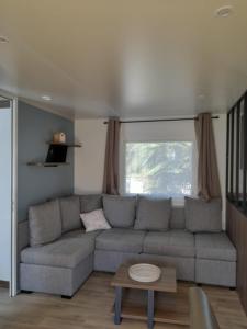ein Wohnzimmer mit einem Sofa und einem Tisch in der Unterkunft camping la carabasse in Vias