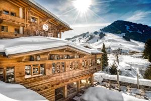 eine Blockhütte mit Schnee auf dem Dach in der Unterkunft Alpin Juwel in Saalbach-Hinterglemm