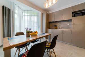 a kitchen and dining room with a wooden table and chairs at Alezzi Luxury Apartments & Spa Center in Mamaia Sat/Năvodari
