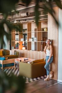 a woman leaning against a wall in a living room at Noli Malmi in Helsinki