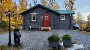 eine kleine Hütte mit einer Bärenstatue davor in der Unterkunft Messlingen 412, Funäsdalen in Funäsdalen