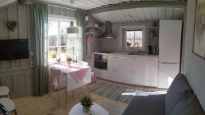 cocina con mesa y cocina con armarios blancos en Messlingen 412, Funäsdalen en Funäsdalen