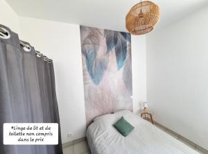 una piccola camera da letto con un letto con un cartello sul muro di La Cabane de l'Océan à 100 m de la plage a Mimizan-Plage