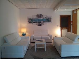 グラードにあるHotel Moreriのリビングルーム(白いソファ2台、テーブル付)