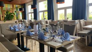 uma sala de jantar com mesas e cadeiras com copos e guardanapos em Berghotel Glockenberg em Sankt Andreasberg
