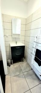 La salle de bains est pourvue d'un lavabo et d'un miroir. dans l'établissement Wifi Clim Garage Jardin BBQ Cosy House, à Brive-la-Gaillarde