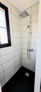 a bathroom with a shower with a window at Wifi Clim Garage Jardin BBQ Cosy House in Brive-la-Gaillarde