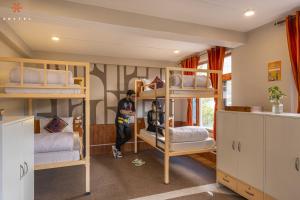 a man standing in a room with bunk beds at Zostel Old Manali in Manāli