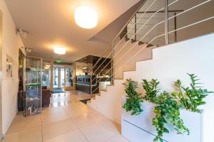 a lobby with stairs and potted plants at Penzion Set in Košice