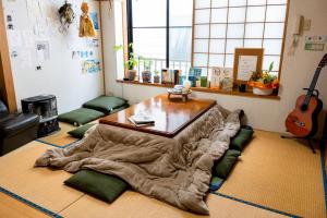 a room with a table with a blanket on the floor at Soma Guesthouse mawari in Soma