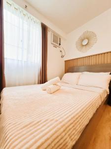 a bedroom with a large bed with a large window at Cozy 1BR Condo near Airport Davao City in Davao City