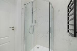 a shower with a glass door in a bathroom at Classy Cracow Apartments Rakowicka by Renters in Krakow