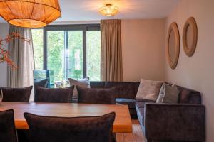 ein Wohnzimmer mit einem Tisch und einem Sofa in der Unterkunft Parc La Dune Dutch Lodge in Warmenhuizen