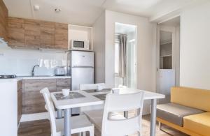 een keuken en eetkamer met een witte tafel en stoelen bij Fabulous village in Casal Palocco