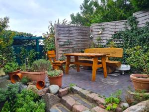 una mesa de picnic de madera y un banco en un jardín en Hus Sünnschien, en Alt Reddevitz