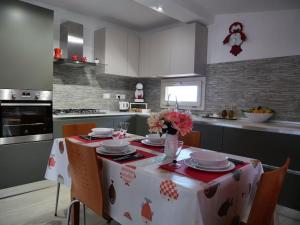 d'une cuisine avec une table avec des assiettes et des fleurs. dans l'établissement Jacuzzi, Vista Mare, Due Ampi Terrazzi Esclusivi, à Camporosso