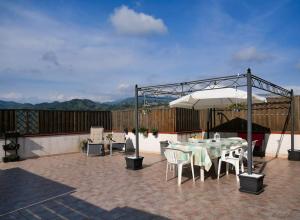une terrasse avec une table et un parasol dans l'établissement Jacuzzi, Vista Mare, Due Ampi Terrazzi Esclusivi, à Camporosso
