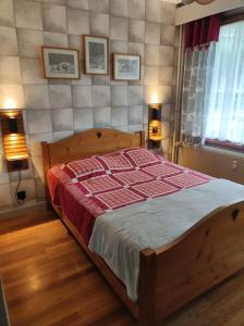 a bedroom with a wooden bed with a red blanket at Appartement Morzine 1000 - 6 pers in Morzine