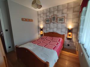 a bedroom with a bed with a red and white comforter at Appartement Morzine 1000 - 6 pers in Morzine