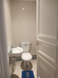 uma casa de banho com um WC branco e um lavatório. em Kamel 114 em Houmt Souk