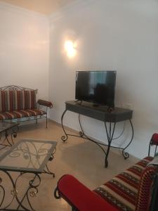 uma sala de estar com uma televisão de ecrã plano sobre uma mesa em Kamel 114 em Houmt Souk