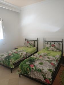 duas camas sentadas uma ao lado da outra num quarto em Kamel 114 em Houmt Souk