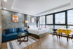 pokój hotelowy z łóżkiem i niebieską kanapą w obiekcie Westlake Emerald Suites w mieście Hanoi