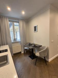 a kitchen with a table and a chair in a room at COZY apartment in the City Center in Vilnius