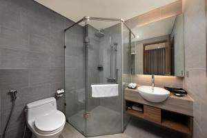 a bathroom with a shower and a toilet and a sink at Avora Hotel in Danang