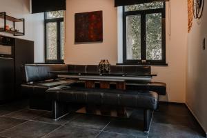 a dining room with leather furniture and windows at Queen's Avenue in Spa