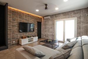 sala de estar con sofá y pared de ladrillo en Villa Alex, en La Isleta del Moro