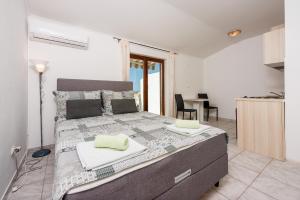 1 dormitorio con 1 cama y cocina con mesa en Nina, en Crikvenica