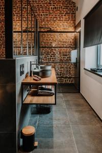 a kitchen with a counter and a brick wall at Queen's Avenue, Wellness and free station E-Car in Spa