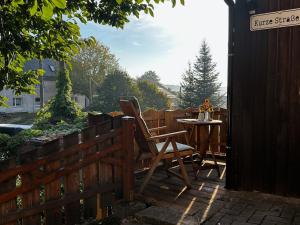 a patio with a table and chairs on a deck at Urlaub im Oberstübchen in Lichtenhain