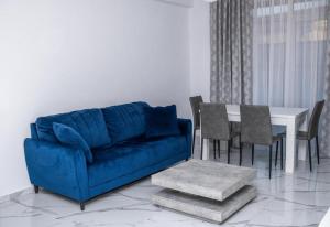 a living room with a blue couch and a table at BB Residence in Arad