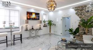 a living room with a table and a chandelier at LUXXLOFT Luxusapartments Wetzlar in Wetzlar