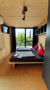 a bedroom with two beds and a large window at GLÜCK HOMES Baumhaus in Ippesheim