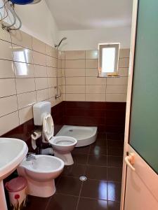 a bathroom with two toilets and a sink at Room rental in Velipojë