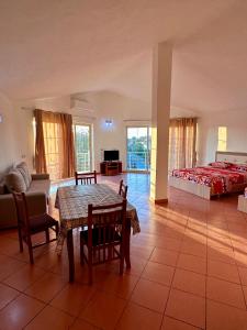 a living room with a table and a bed at Room rental in Velipojë