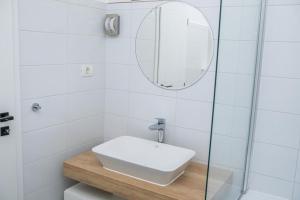 a white bathroom with a sink and a mirror at BB Residence in Arad