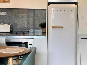 - un réfrigérateur blanc dans la cuisine avec une table dans l'établissement Loft acogedor cerca de Barcelona, à Terrassa