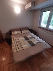 a large bed in a room with a window at Zagrebska flat in Skopje