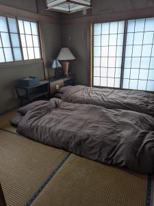 a large bed in a room with windows at 小江戸川越ハウス in Kawagoe