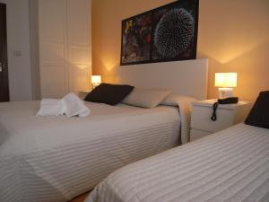 una camera d'albergo con due letti e due lampade di Hotel Moreri a Grado