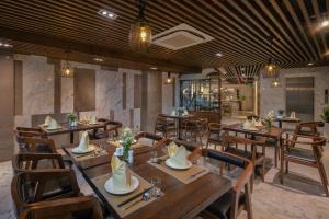 a dining room with wooden tables and chairs at Avora Hotel in Da Nang