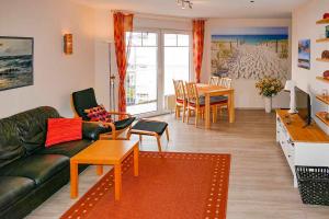 ein Wohnzimmer mit einem Sofa und einem Tisch in der Unterkunft Ferienappartement Fraenzi mit herrlichem Seeblick in Sassnitz
