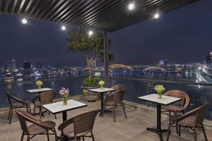 d'une terrasse avec tables et chaises et vue sur la ville. dans l'établissement Avora Hotel, à Đà Nẵng