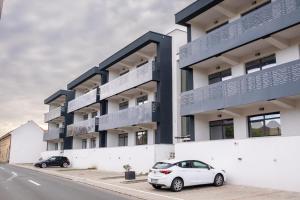 two cars parked in front of a building at BB Residence in Arad