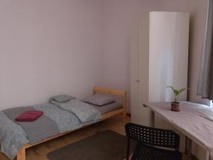 una camera da letto con due letti, un tavolo e una sedia di Cruz Mieszkanie Pokoje Centrum przytulny czysty lokal na noc a Łódź